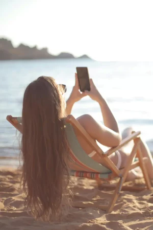 femme plage regarde portable